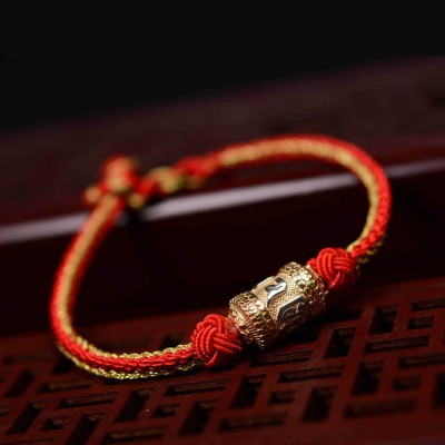 The red string is a symbol of protection, warding off negative energy, and attracting good fortune